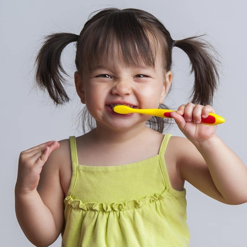 Niña Cuidando sus dientes